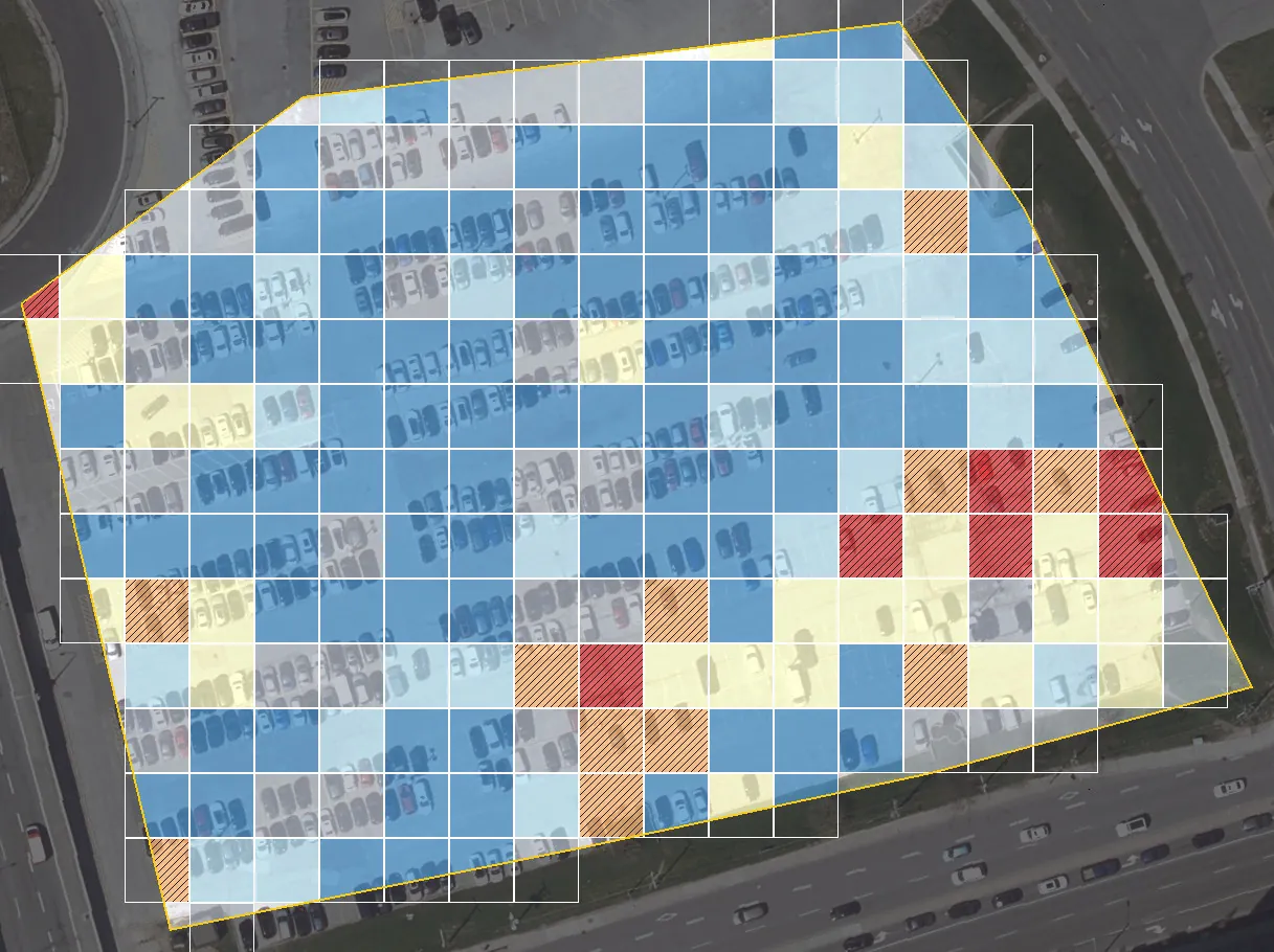 The same lot divided into 10 m cells coloured by the length of crack-like lines in each: mostly blue (very few lines), with a cluster of orange and red hatched cells where the surface is cracked.