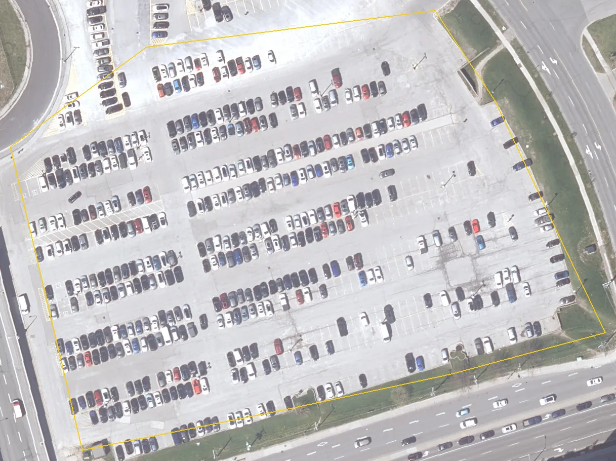 Aerial photograph of a commuter parking lot in Toronto in 2023, with its paved area outlined in yellow.